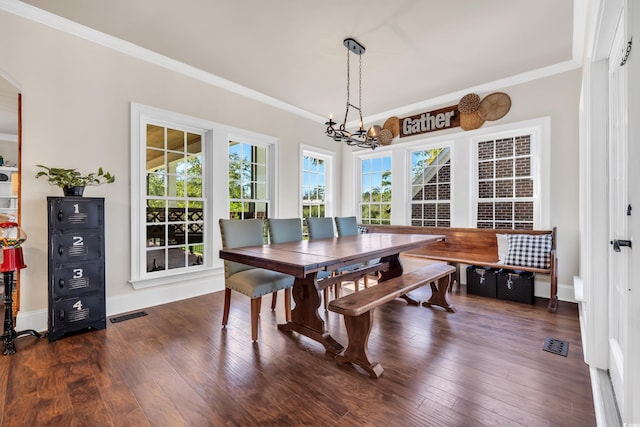 dining area with visible vents, baseboards, hardwood / wood-style floors, crown molding, and a notable chandelier