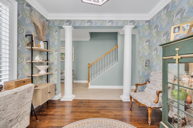 living area featuring wallpapered walls, decorative columns, and crown molding