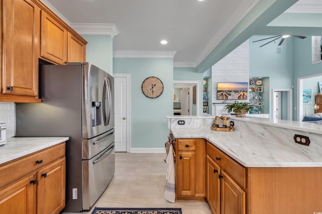 kitchen featuring light stone counters, brown cabinetry, crown molding, and backsplash