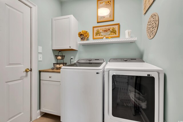 washroom featuring cabinet space and independent washer and dryer