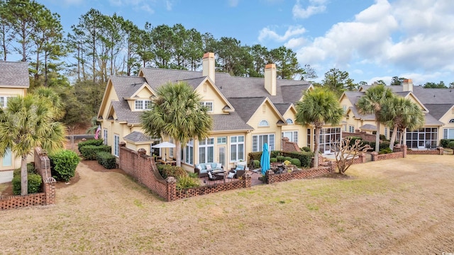 back of house with roof with shingles, a residential view, a lawn, and a patio