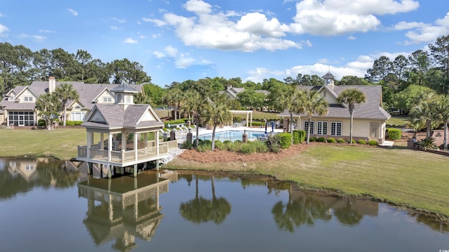 back of property featuring a gazebo, a lawn, a water view, and an outdoor pool