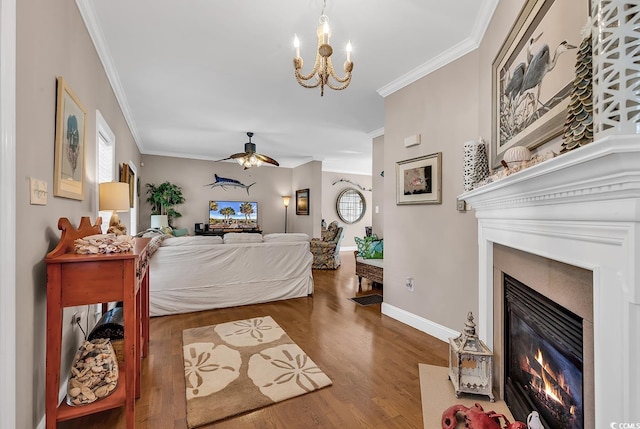 living area with baseboards, a fireplace with flush hearth, ornamental molding, and wood finished floors