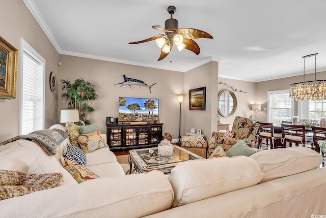 living area with ornamental molding, wood finished floors, and ceiling fan with notable chandelier