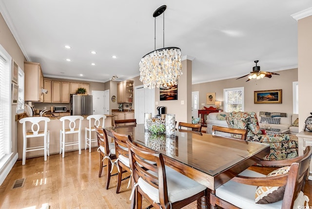 dining room featuring ornamental molding, visible vents, and light wood-style floors