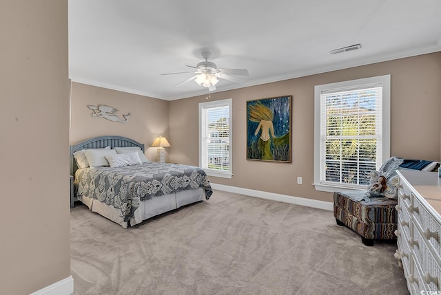 carpeted bedroom featuring ornamental molding, a ceiling fan, visible vents, and baseboards