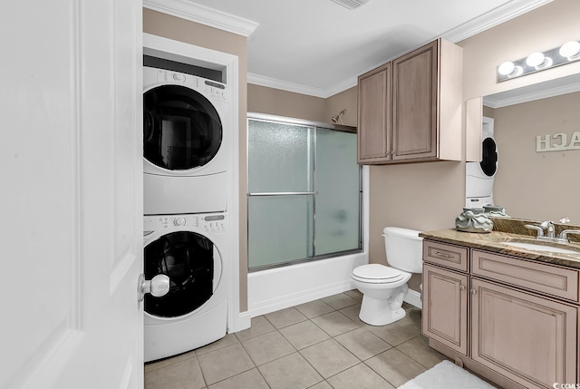 full bath featuring toilet, crown molding, stacked washer / dryer, and tile patterned floors