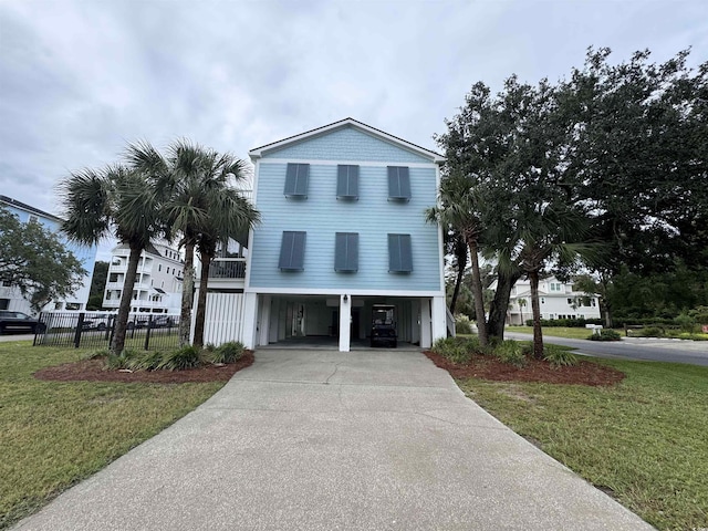 raised beach house with a carport, a front yard, fence, and driveway