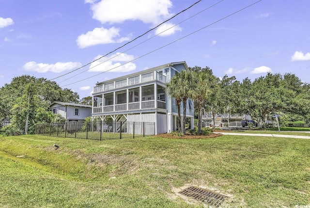 exterior space with a lawn, fence, and a sunroom