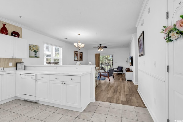 kitchen featuring light tile patterned floors, dishwasher, a peninsula, light countertops, and white cabinetry