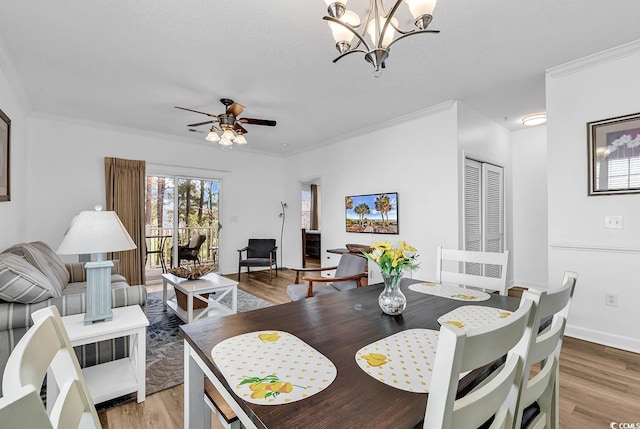 dining space featuring ornamental molding, baseboards, light wood finished floors, and ceiling fan with notable chandelier