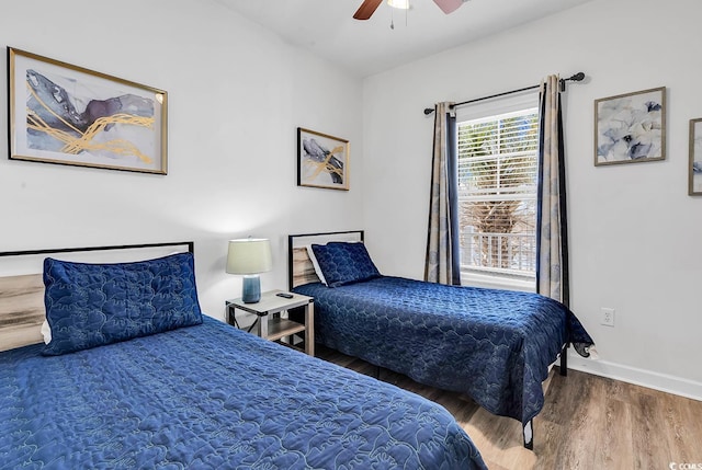 bedroom with wood finished floors, a ceiling fan, and baseboards