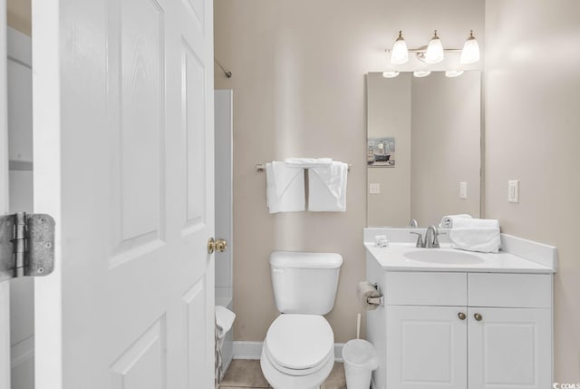 bathroom with vanity, toilet, and baseboards