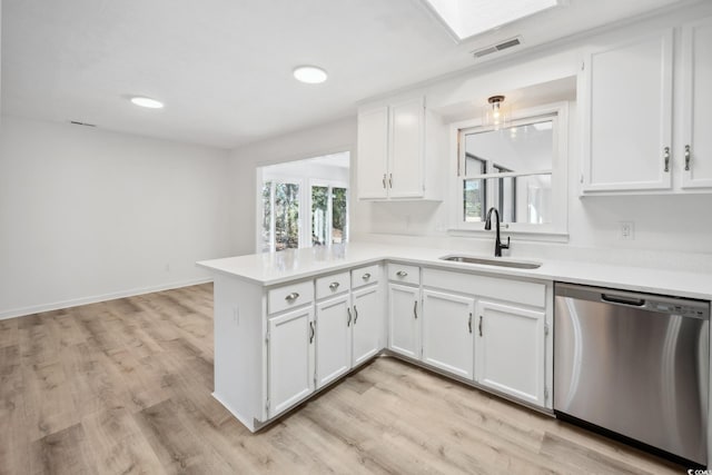 kitchen with visible vents, stainless steel dishwasher, white cabinetry, a sink, and a peninsula