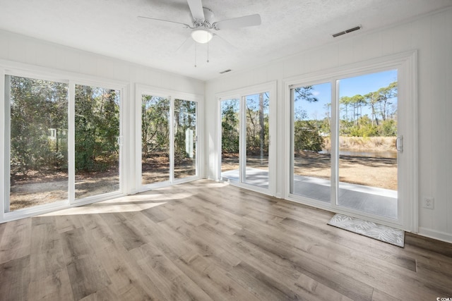 unfurnished sunroom featuring ceiling fan and visible vents