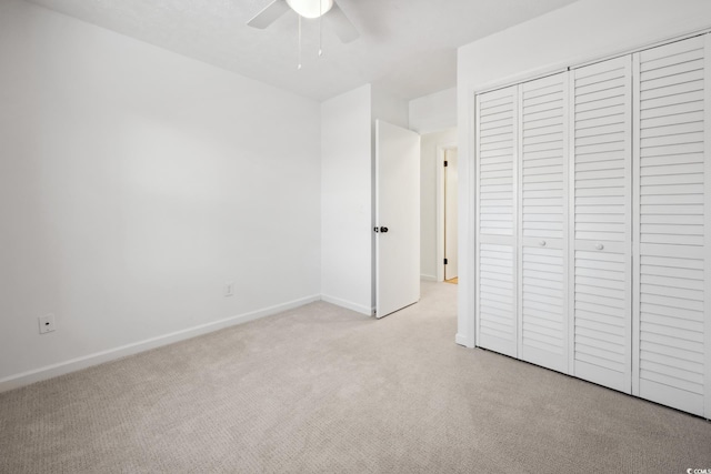 unfurnished bedroom with light carpet, a ceiling fan, baseboards, and a closet