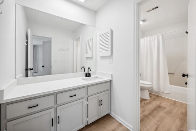 bathroom featuring toilet, wood finished floors, vanity, and visible vents