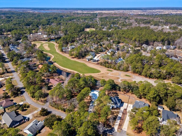 bird's eye view featuring view of golf course and a forest view