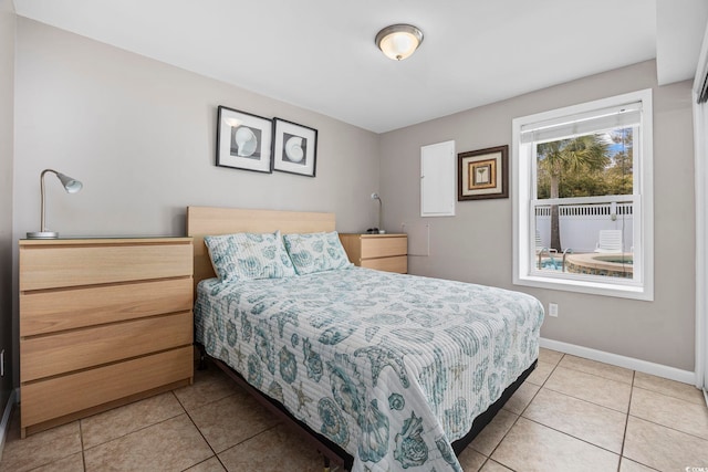 bedroom with light tile patterned floors and baseboards