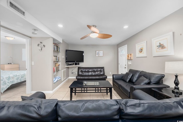 living area featuring ceiling fan, baseboards, visible vents, and light tile patterned floors