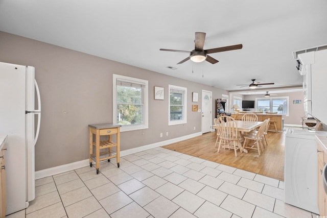 dining space featuring light wood-style flooring, visible vents, ceiling fan, and baseboards