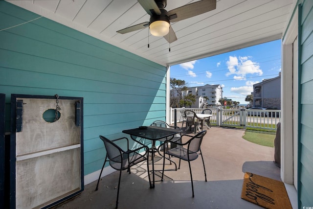 view of patio featuring ceiling fan, outdoor dining space, fence, and a gate