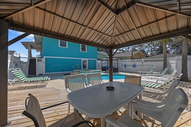 view of patio featuring a fenced in pool, a fenced backyard, a deck, a gazebo, and outdoor dining space