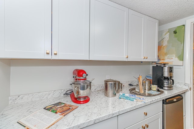 kitchen featuring white cabinetry and a textured ceiling