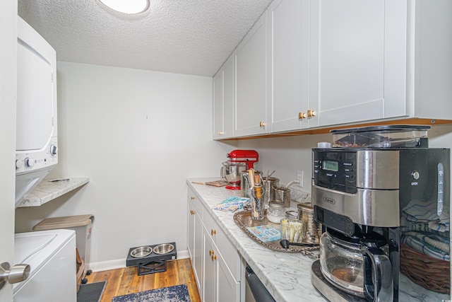 kitchen with baseboards, light stone countertops, a textured ceiling, light wood-style floors, and white cabinetry