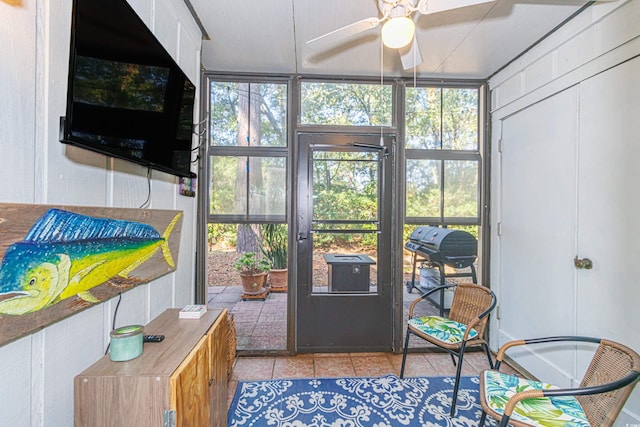 doorway with ceiling fan and light tile patterned floors