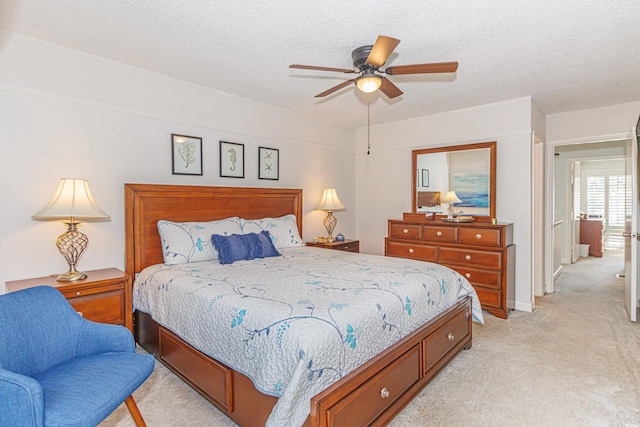 bedroom with light carpet, a ceiling fan, and a textured ceiling