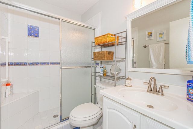 bathroom with a stall shower, vanity, and toilet