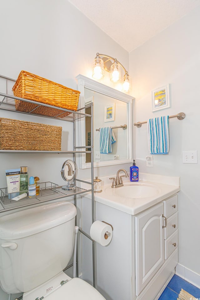 half bath featuring toilet, baseboards, and vanity