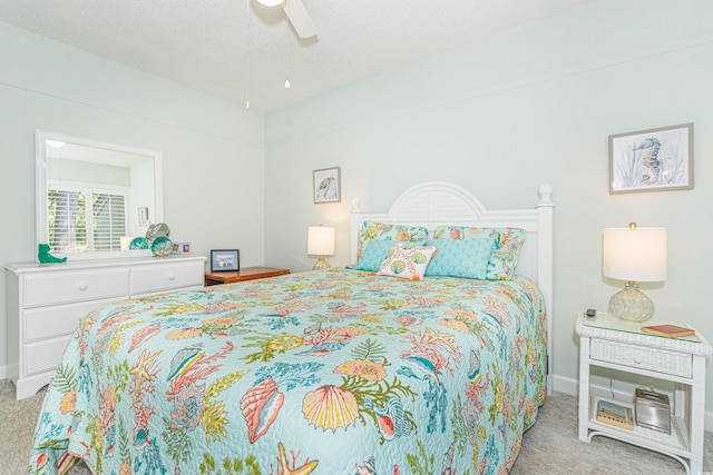 carpeted bedroom featuring a ceiling fan, a textured ceiling, and baseboards