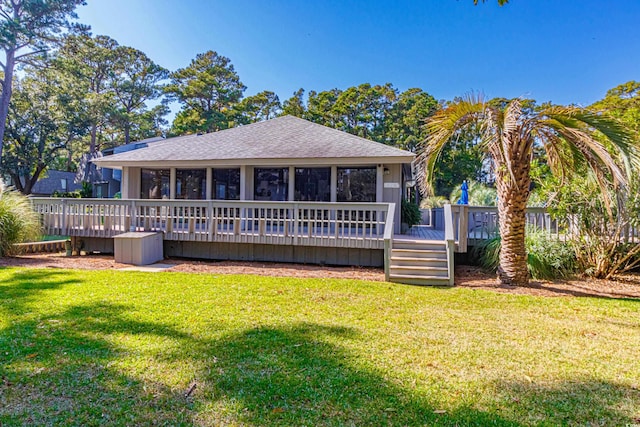 rear view of property featuring a wooden deck, a shingled roof, and a yard