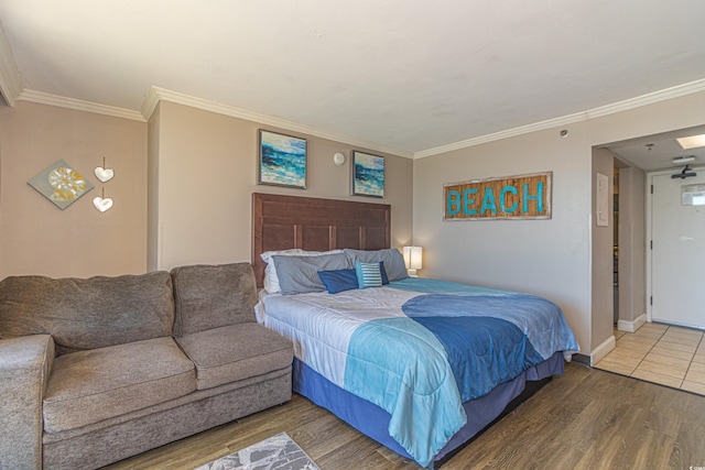 bedroom featuring baseboards, ornamental molding, and wood finished floors