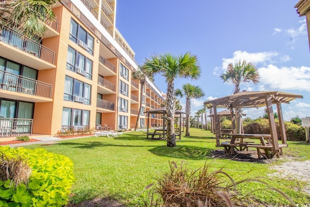 view of community with a yard and a pergola