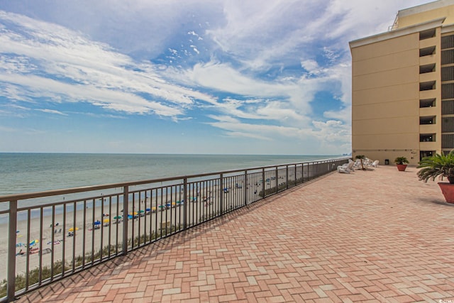 view of patio / terrace featuring a water view and a view of the beach