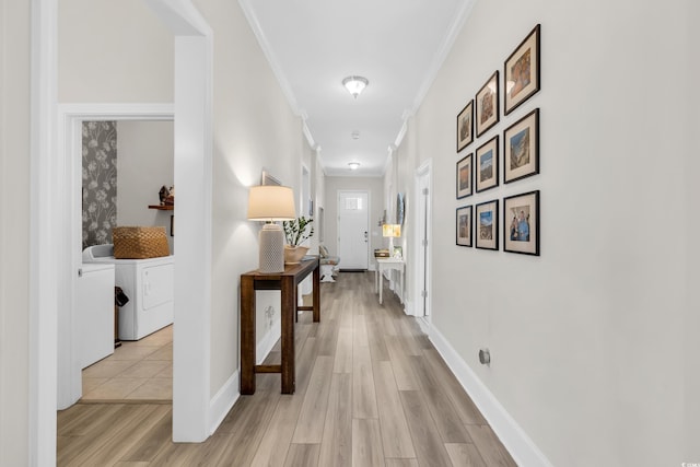 hallway featuring light wood finished floors, crown molding, and independent washer and dryer