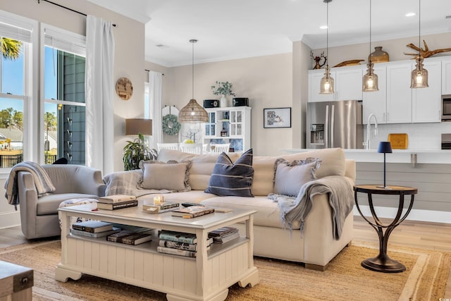 living room featuring recessed lighting, light wood-type flooring, and crown molding