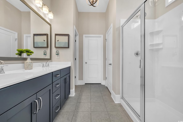 full bathroom with double vanity, a shower stall, a sink, and tile patterned floors