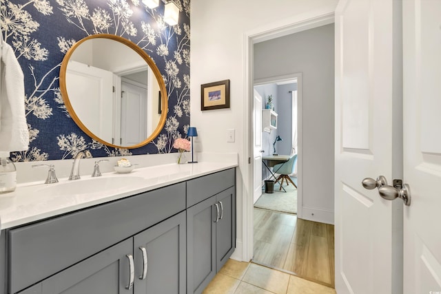 bathroom featuring wallpapered walls, tile patterned flooring, baseboards, and vanity