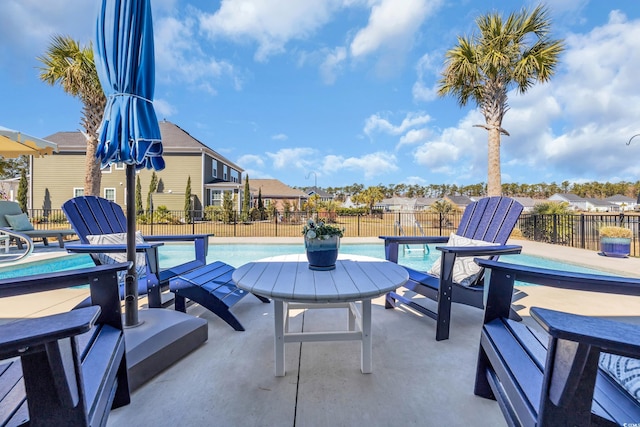 view of patio / terrace with a community pool and fence