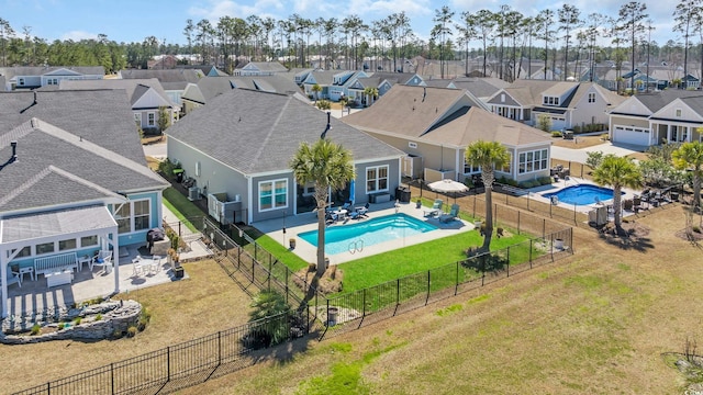 view of pool with a patio, a lawn, a fenced backyard, and a residential view