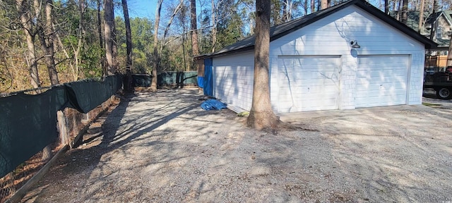 detached garage featuring fence