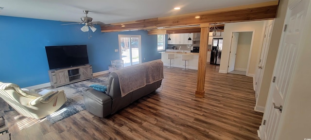 living area with baseboards, dark wood finished floors, a ceiling fan, beam ceiling, and recessed lighting