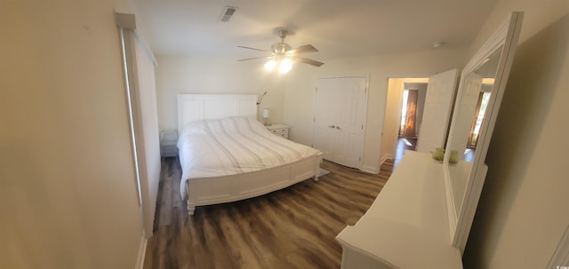 unfurnished bedroom with a closet, visible vents, dark wood-type flooring, a ceiling fan, and baseboards