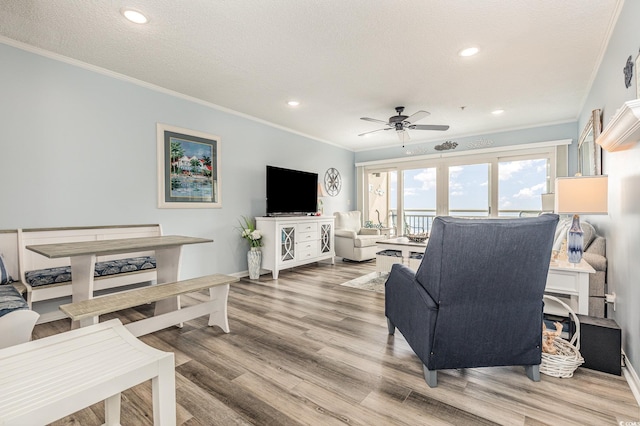 living room featuring crown molding, recessed lighting, a ceiling fan, a textured ceiling, and wood finished floors