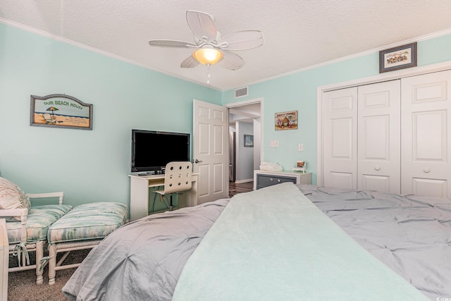 bedroom featuring carpet floors, crown molding, a closet, visible vents, and a textured ceiling