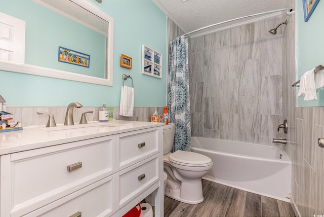 bathroom featuring toilet, shower / tub combo, vanity, a textured ceiling, and wood finished floors